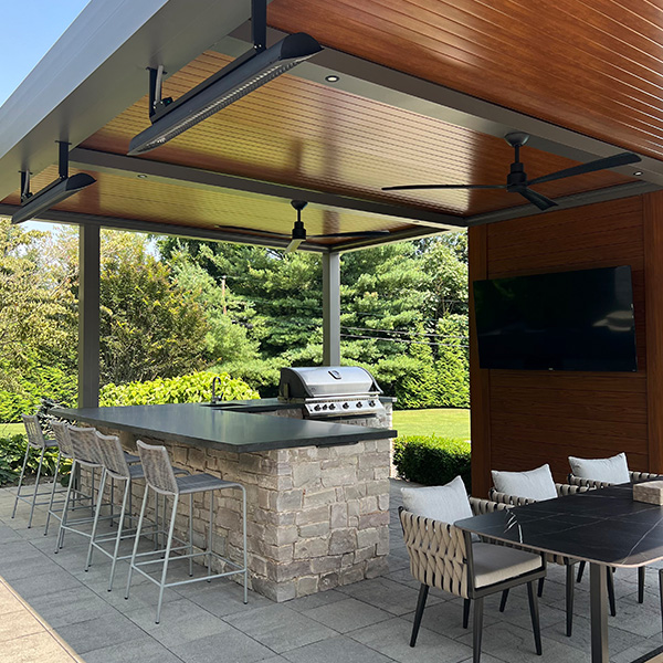 Outdoor kitchen and bar in NJ. The Azenco pergola protect the Wall TV, the cooking and dinign stations.